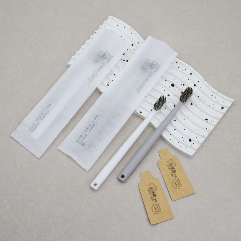 通货-灰白八角喷砂无纺布（送纸袋牙膏） 牙刷克重：全新料10克pp聚丙烯 刷毛：0.15mm咖棕火焰毛 牙膏：3g氨基酸牙膏 包装：三边封无纺布 孔数：31孔（1000/箱）整箱起发）